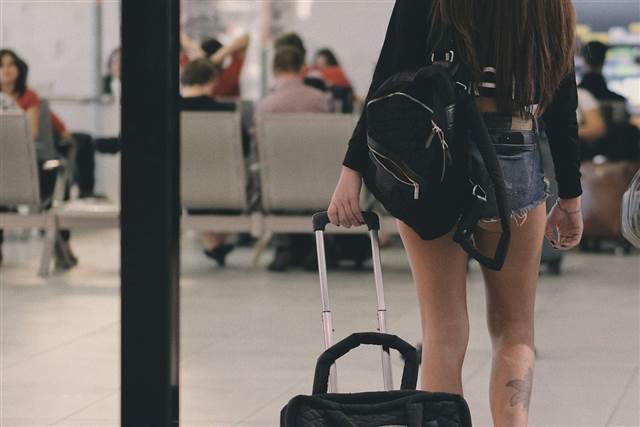 Viajante caminhando em aeroporto com mala